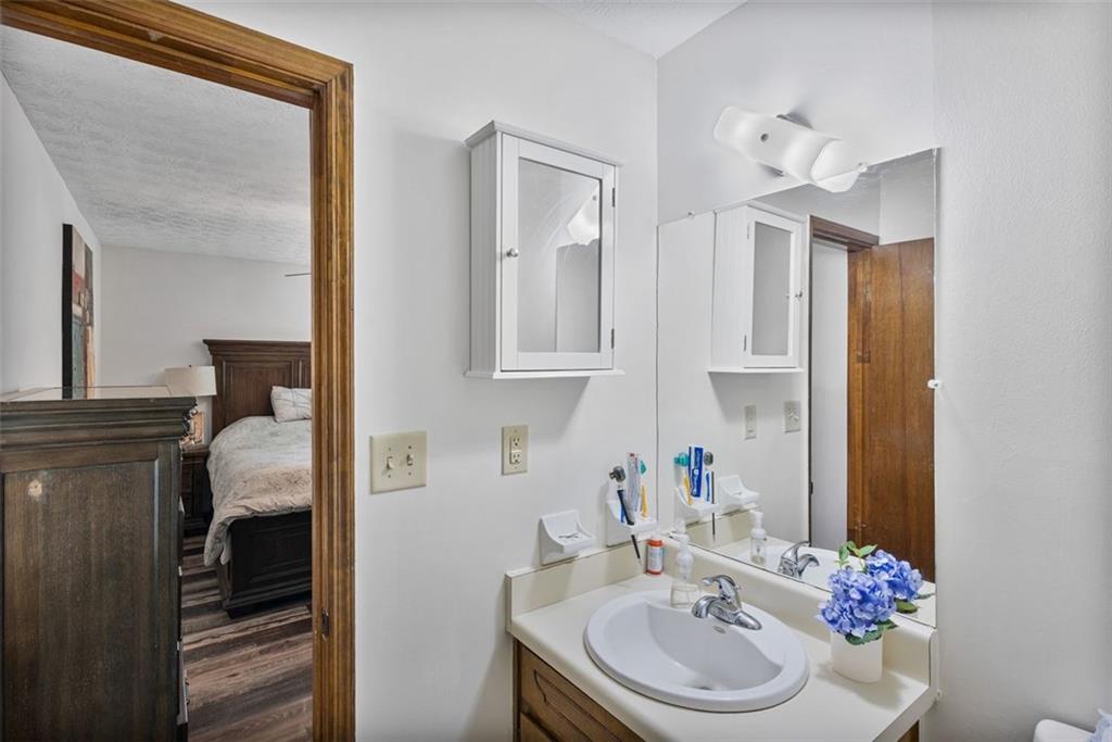 5865 Vernier Drive Southwest Atlanta, GA 30349 - Photo 24 of 33 a bathroom with a granite countertop sink and a mirror