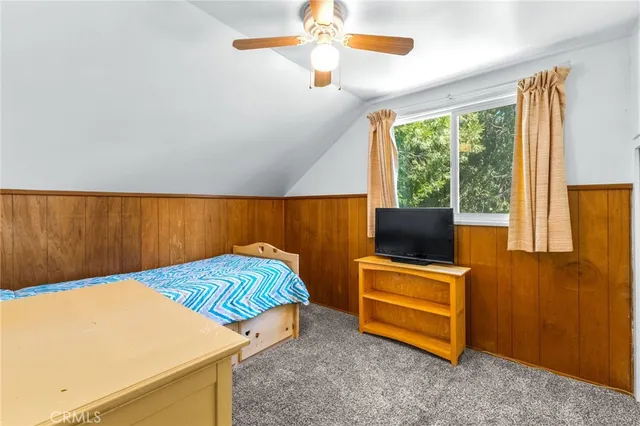 a living room with a bed furniture and a flat screen tv