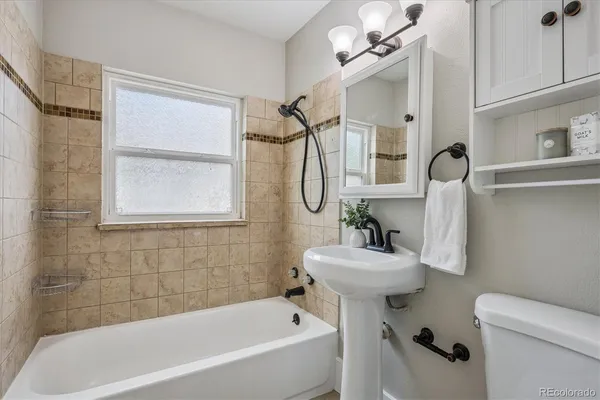 a bathroom with a sink mirror bathtub and toilet