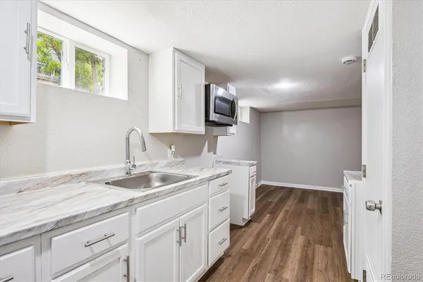 a kitchen with a sink and wooden floor
