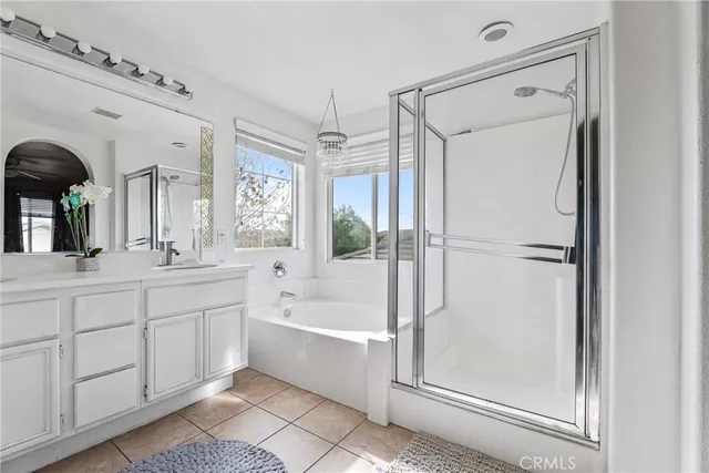 a spacious bathroom with a tub mirror and a sink
