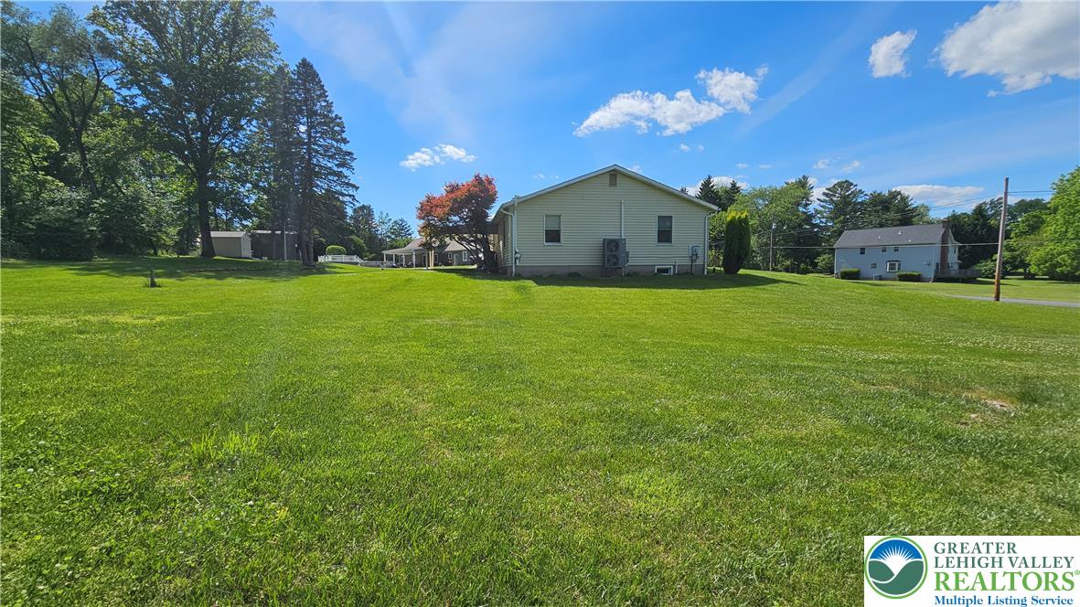 2810 County Line Road Riegelsville, PA 18077 - Photo 7 of 7 A spacious yard surrounds this charming home, offering ample outdoor living space under a clear sky.