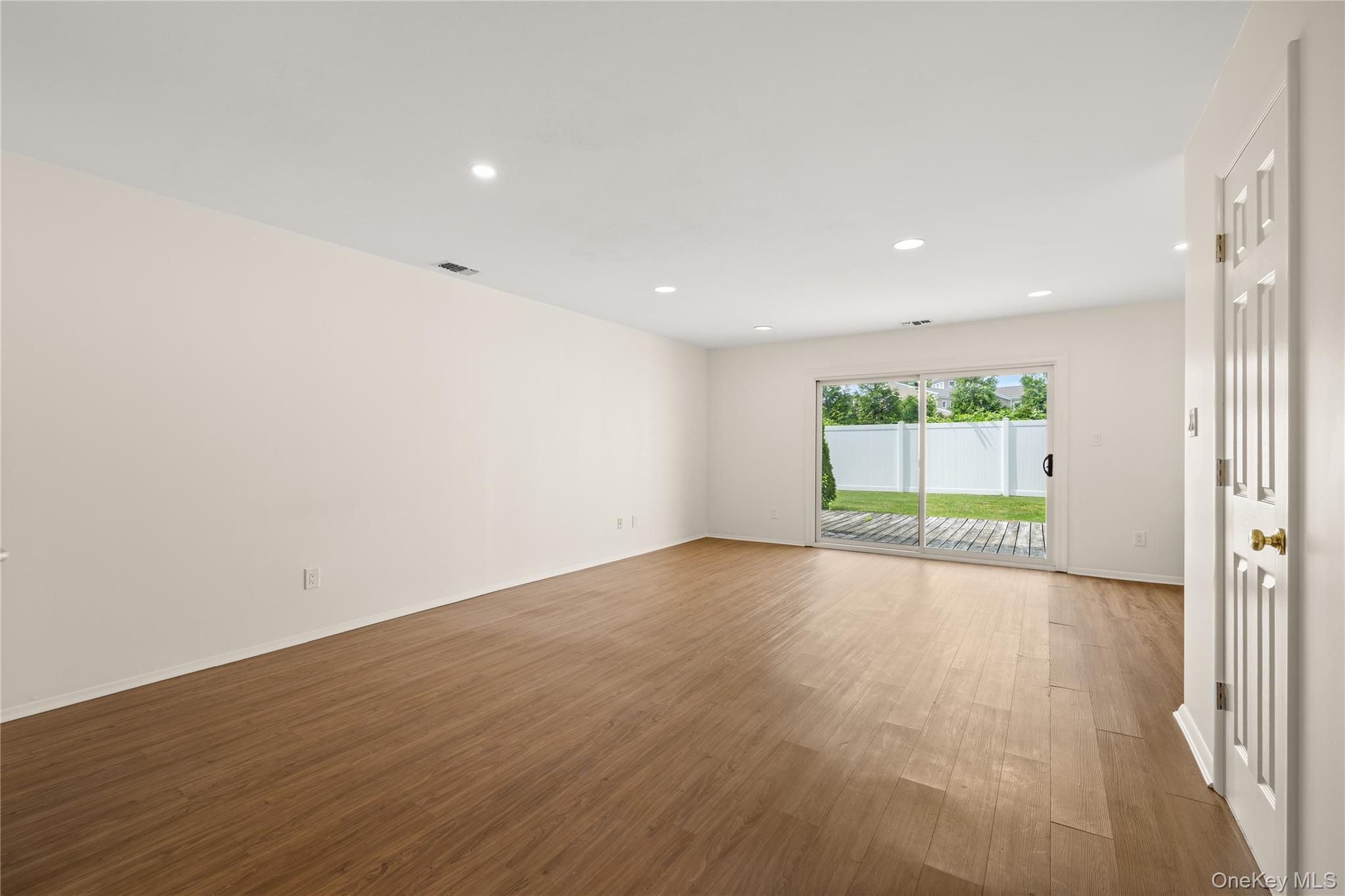 650 Newbridge Road, Unit 15 East Meadow, NY 11554 - Photo 8 of 20 an empty room with wooden floor and windows