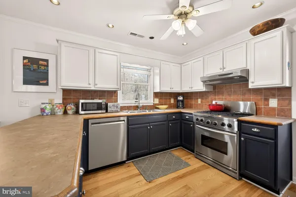a kitchen with stainless steel appliances granite countertop a stove sink and cabinets