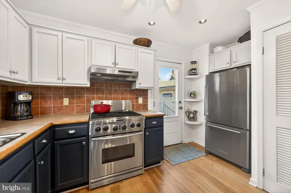 a kitchen with stainless steel appliances granite countertop a stove a refrigerator and a cabinets
