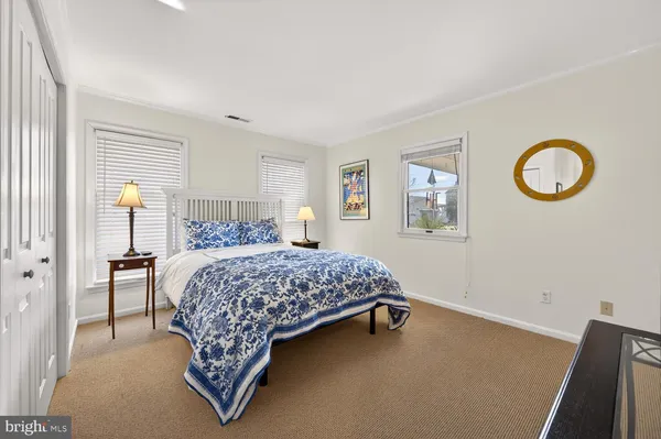 a bedroom with a bed and painting on the wall
