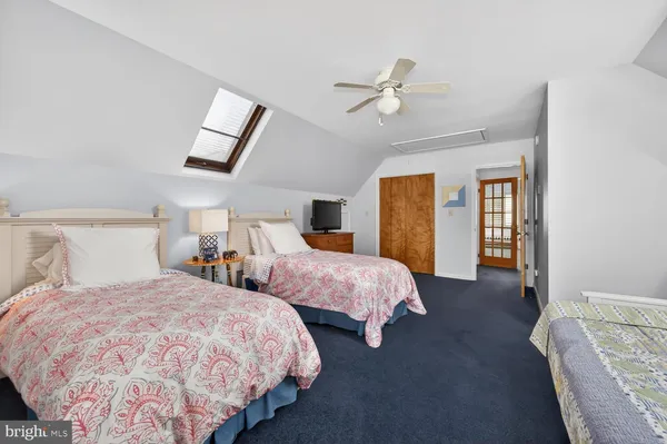 a bedroom with two beds and a chandelier