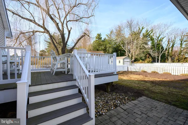 a view of backyard with wooden fence and trees
