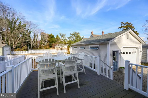a view of a roof deck with table and chairs with wooden floor and fence