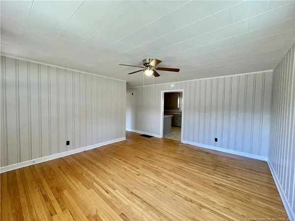 a view of empty room with wooden floor