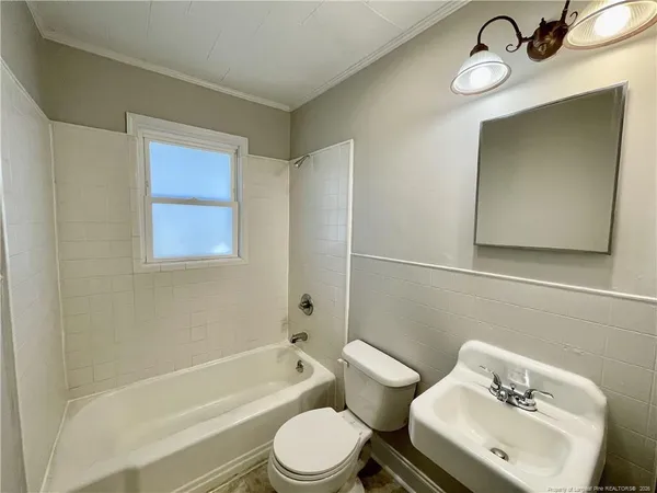 a white toilet sitting next to a bathroom sink and tub