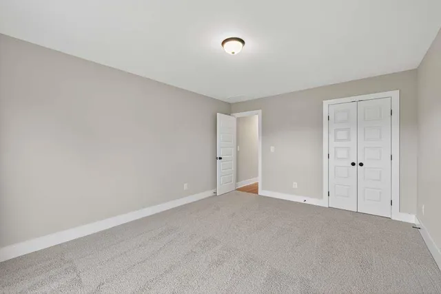 a view of an empty room and chandelier fan