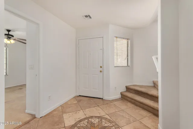 a view of room with stairs and a ceiling fan