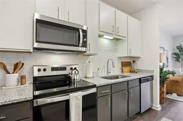 a kitchen with stainless steel appliances granite countertop a sink stove and microwave