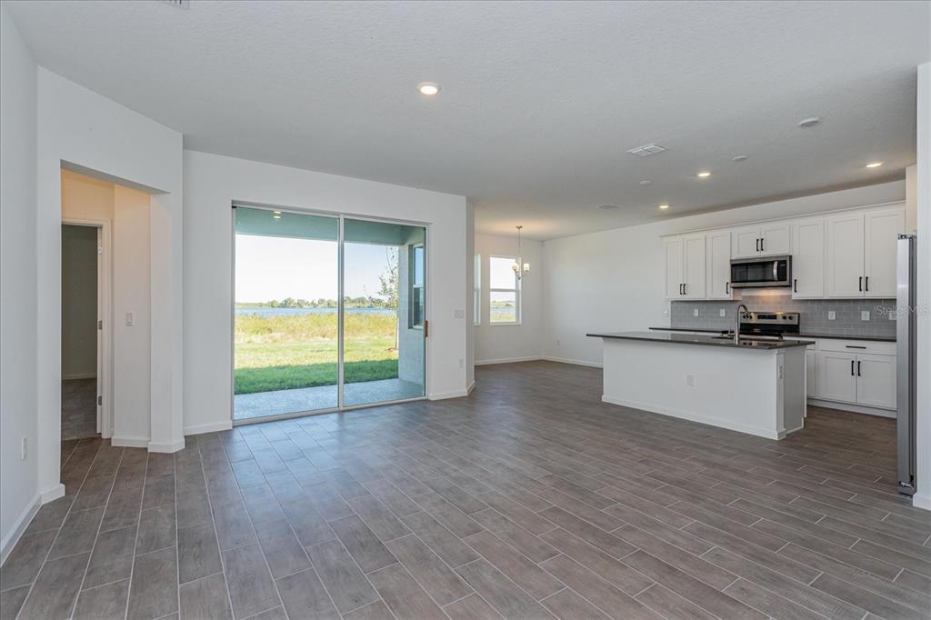 1010 Swamp Chestnut Loop Lady Lake, FL 32159 - Photo 3 of 22 a view of kitchen with refrigerator and wooden floor