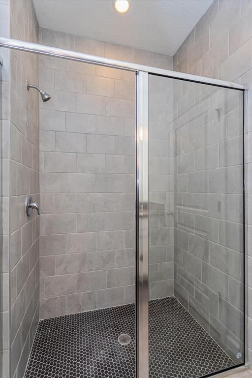 1010 Swamp Chestnut Loop Lady Lake, FL 32159 - Photo 10 of 22 a bathroom with a glass shower door