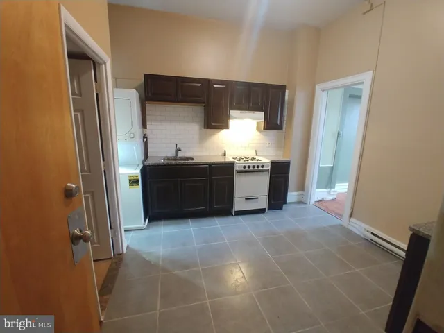 a view of kitchen with stainless steel appliances granite countertop a sink and a refrigerator