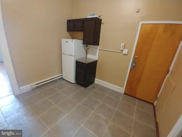 a view of a storage and utility room with refrigerator
