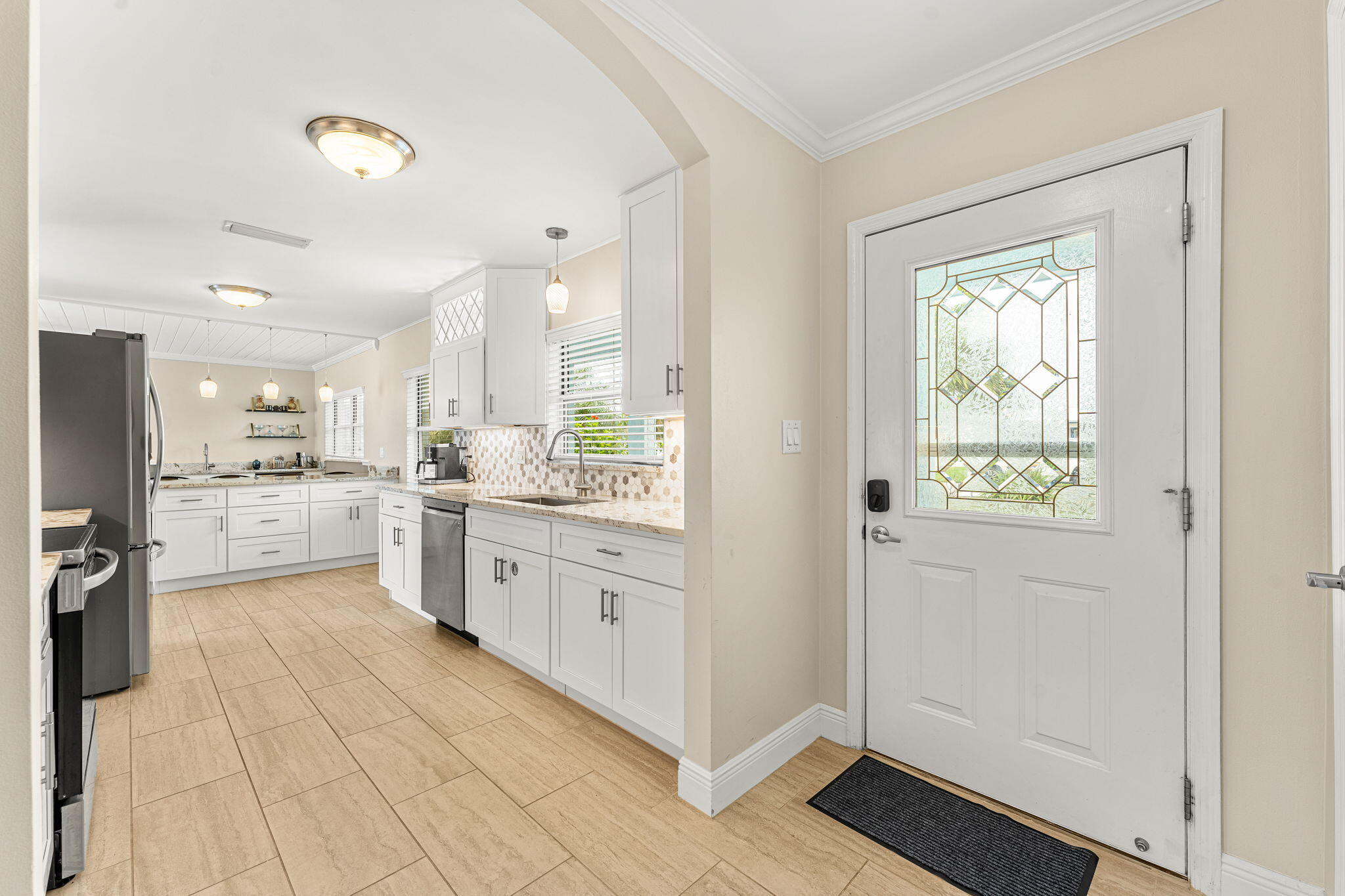 428 Dempsey Drive Cocoa Beach, FL 32931 - Photo 2 of 25 a large white kitchen with granite countertop a large window and white appliances