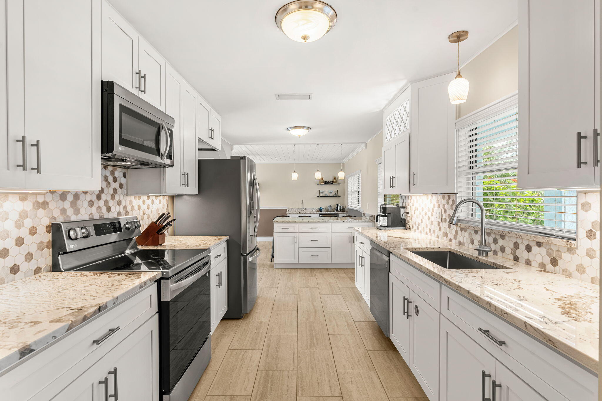428 Dempsey Drive Cocoa Beach, FL 32931 - Photo 3 of 25 a kitchen with stainless steel appliances granite countertop a sink stove microwave and refrigerator