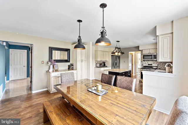 a view of a dining room and livingroom with furniture wooden floor a chandelier