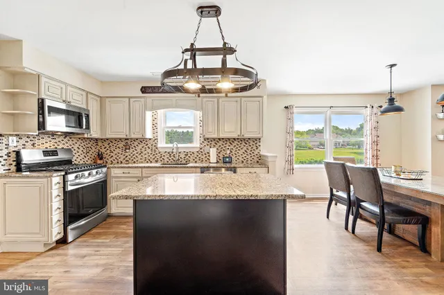 a kitchen with stainless steel appliances granite countertop a stove and a wooden floors