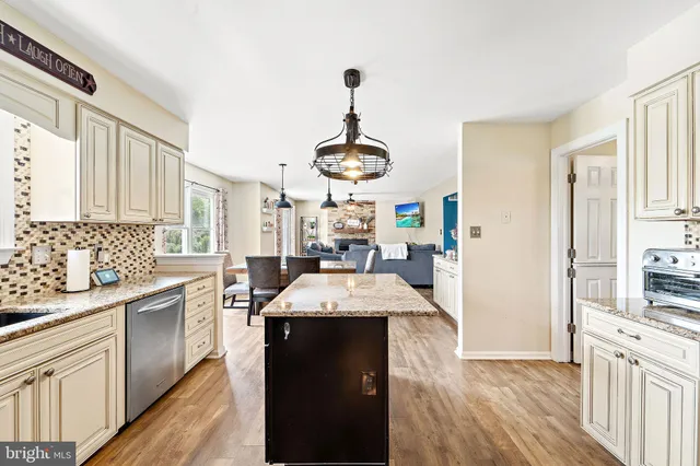 a very nice looking open kitchen with granite countertop a stove top oven
