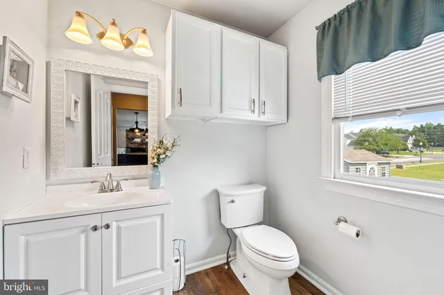 a bathroom with a toilet a sink and a window