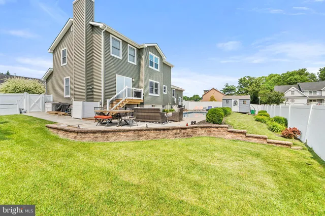 a view of a patio with couches table and chairs with wooden floor and fence
