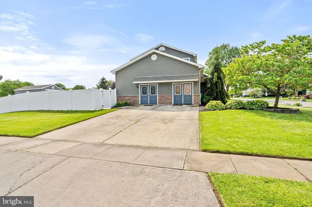 a view of a house with a yard and large tree