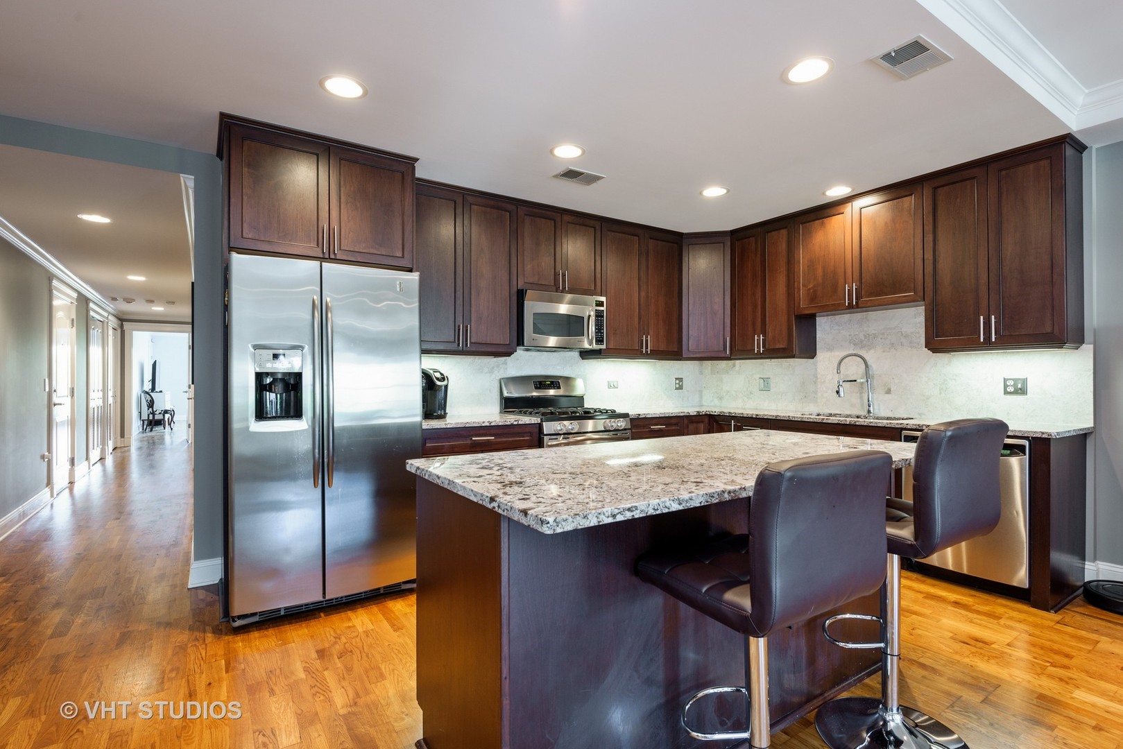 1909 West Diversey Parkway, Unit 302 Chicago, IL 60614 - Photo 4 of 12 a kitchen with stainless steel appliances granite countertop wooden cabinets a refrigerator a sink and a stove