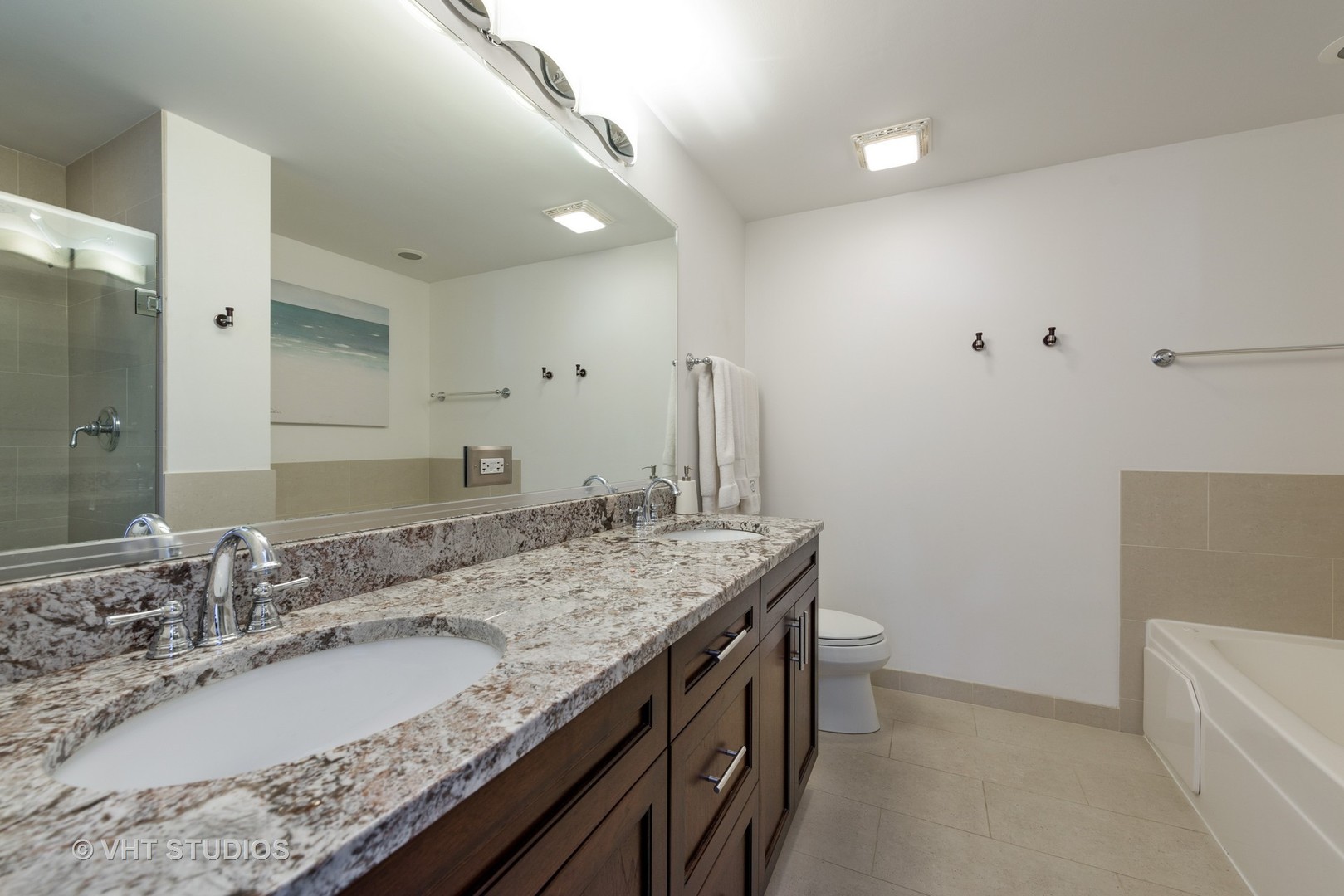 1909 West Diversey Parkway, Unit 302 Chicago, IL 60614 - Photo 7 of 12 a bathroom with a granite countertop sink a mirror and a bathtub