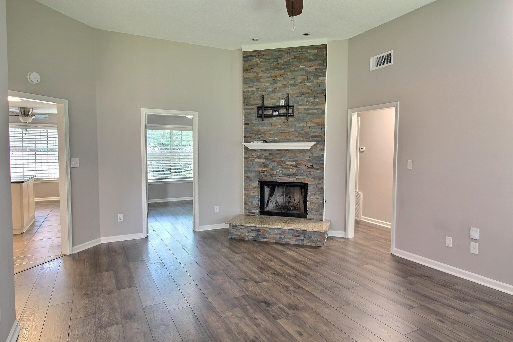 244 Saybrook Cove Collierville, TN 38017 - Photo 7 of 28 an empty room with wooden floor a fireplace and windows