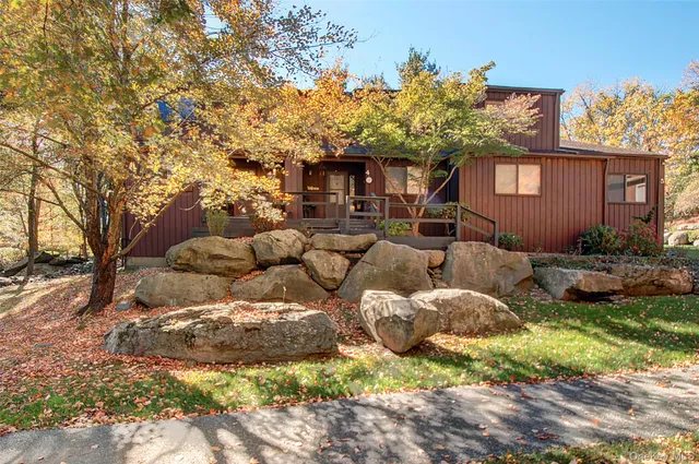 a front view of a house with a yard and outdoor seating