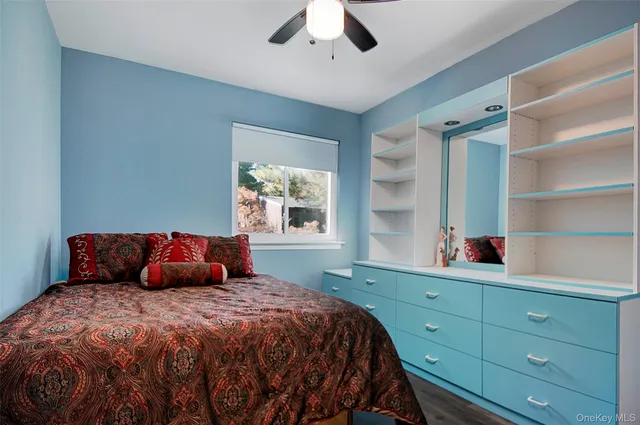 a bedroom with a bed and a dresser next to a window
