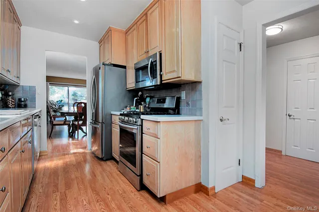 a kitchen with cabinets appliances and a wooden floor