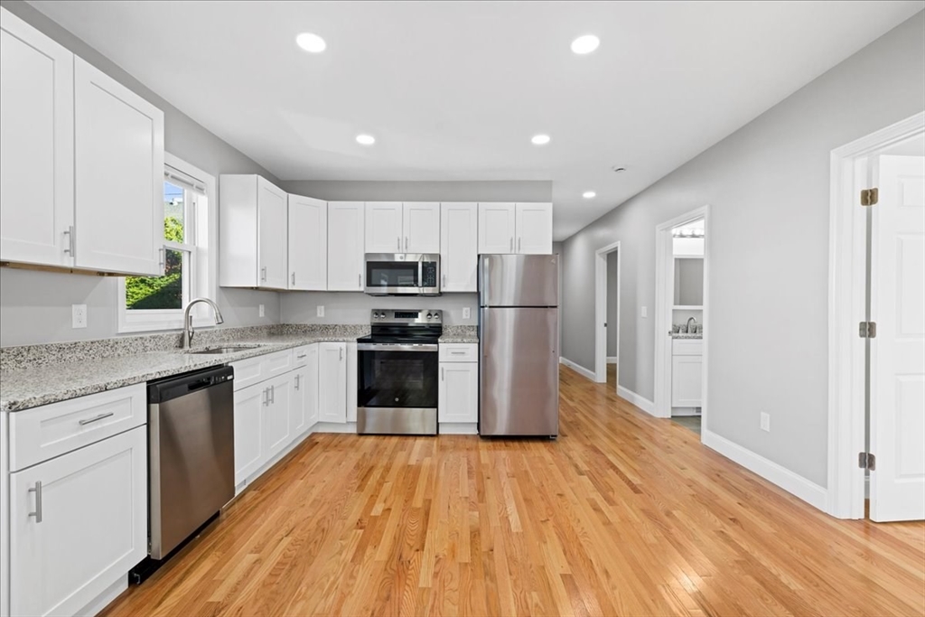 9 Upsala Street, Unit 2 Worcester, MA 01610 - Photo 2 of 29 a kitchen with stainless steel appliances granite countertop a refrigerator a sink dishwasher and a stove with wooden floor