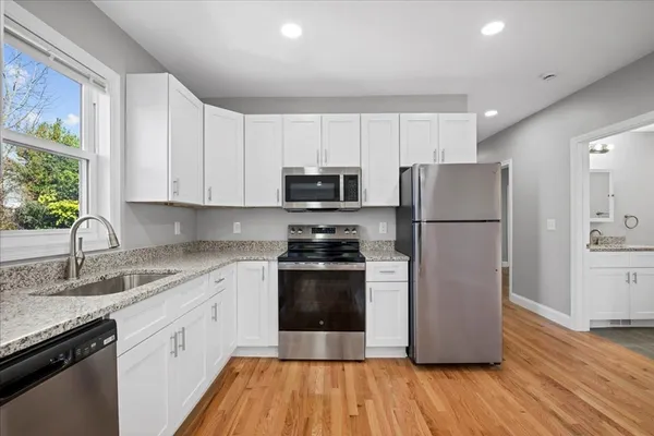 a kitchen with a refrigerator stove and wooden cabinets