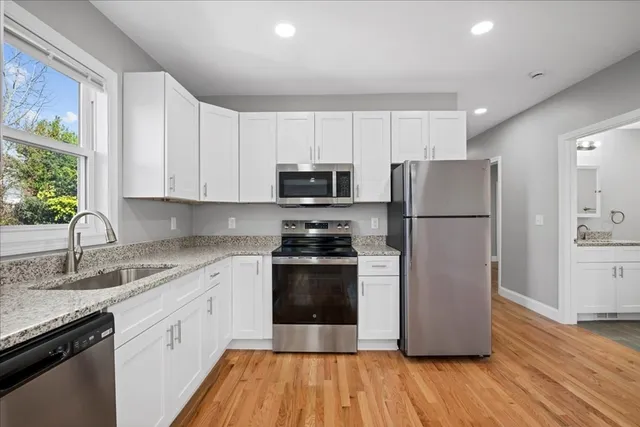 a kitchen with a refrigerator stove and wooden cabinets
