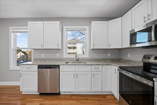 a kitchen with stainless steel appliances granite countertop a stove a sink and a microwave
