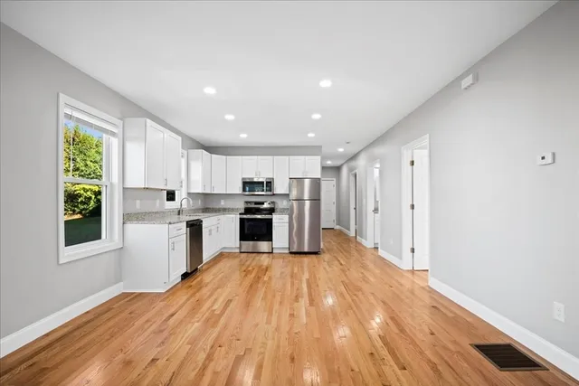 a kitchen with stainless steel appliances granite countertop a refrigerator and a stove top oven