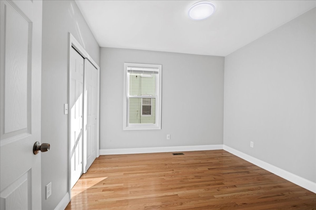 9 Upsala Street, Unit 2 Worcester, MA 01610 - Photo 9 of 29 a view of an empty room with wooden floor and a window