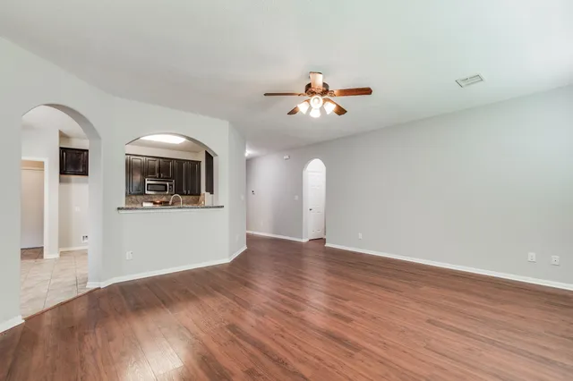 a view of a kitchen with wooden floor and a ceiling fan