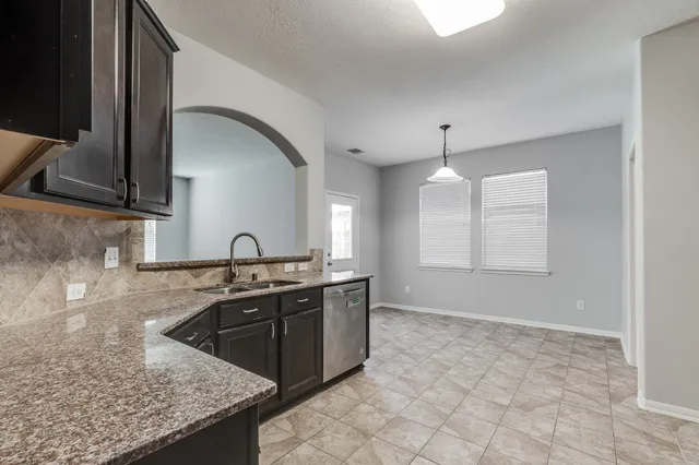 a kitchen with granite countertop a sink and a stove