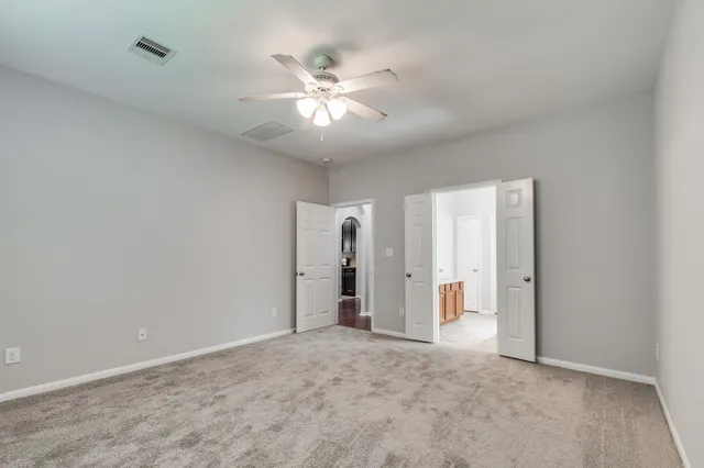 an empty room with a window and a fan