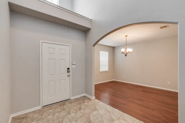 an empty room with wooden floor and mirror