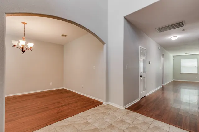 a view of a room with wooden floor and chandelier