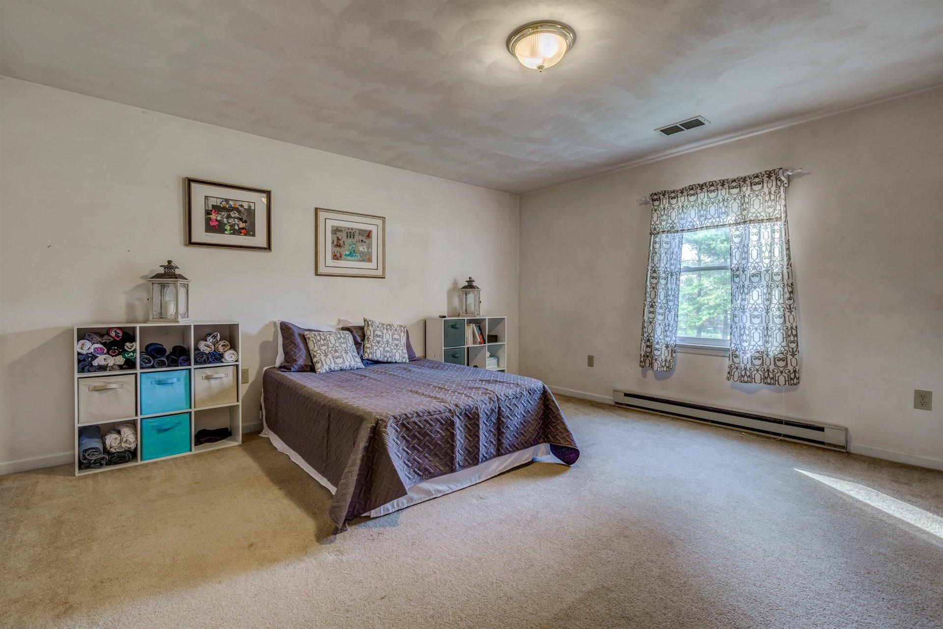 2725 Morgans Mill Road Goodview, VA 24095 - Photo 13 of 49 a spacious bedroom with a bed and a window
