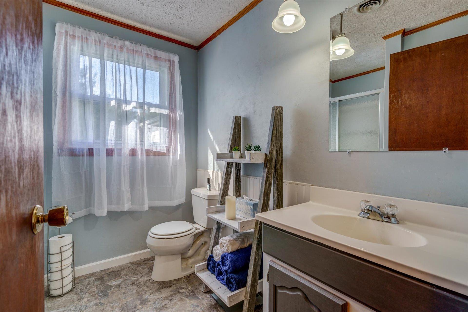 2725 Morgans Mill Road Goodview, VA 24095 - Photo 19 of 49 a bathroom with a granite countertop sink toilet and shower