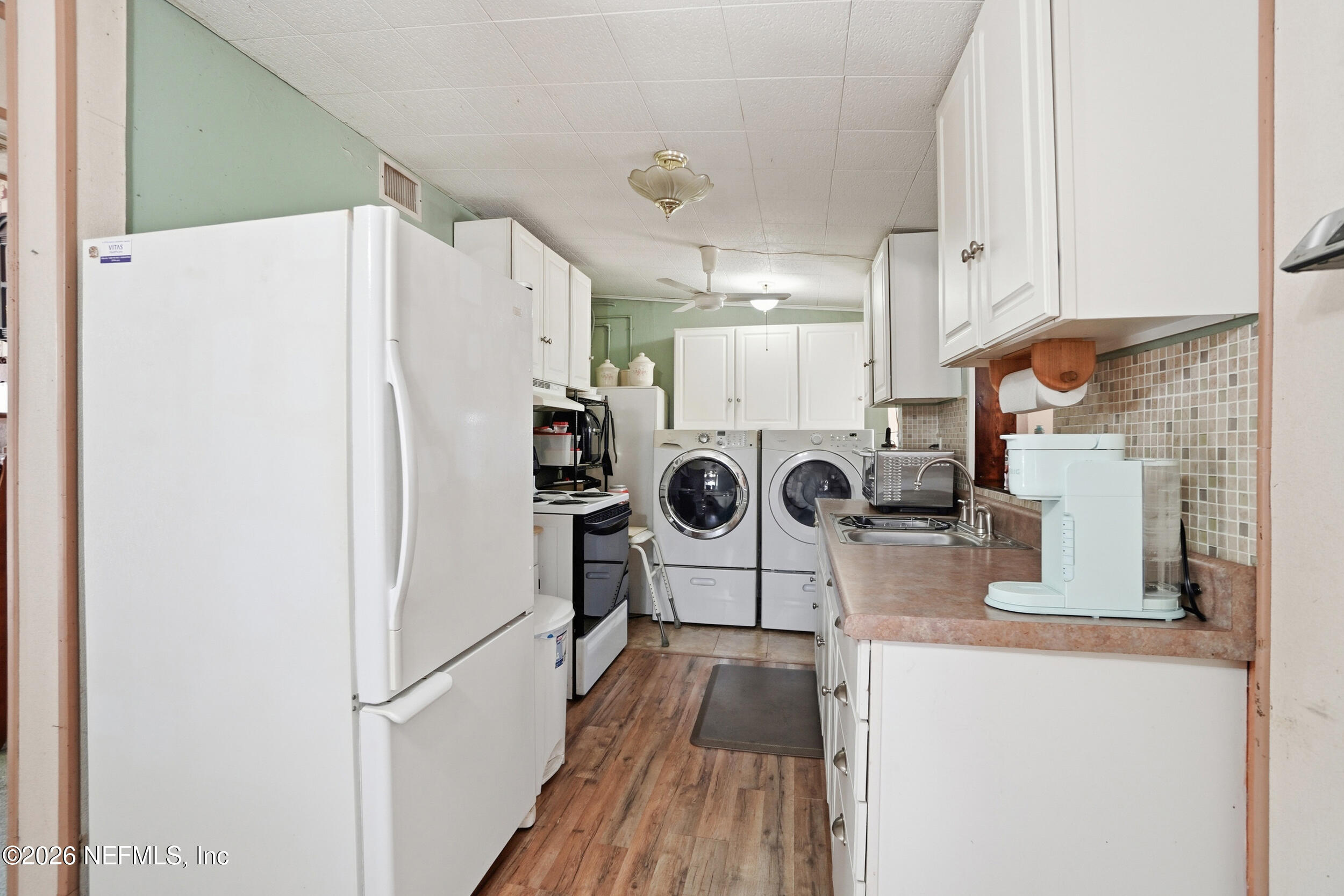 43 Forrestal Circle North Atlantic Beach, FL 32233 - Photo 10 of 39 a kitchen with stainless steel appliances granite countertop a refrigerator a stove and white cabinets with wooden floor